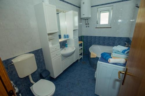a bathroom with a sink and a toilet and a sink at Apartments Meri - 1 in Lopar