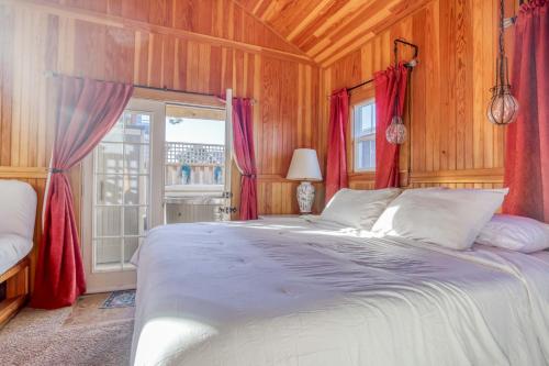 a bedroom with a large bed with red curtains at The Captains Place in Lincoln City
