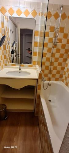 une salle de bain avec un lavabo, une baignoire et un miroir dans l'établissement Sisley 068 - F2 et magnifique vue mer, à Cannes