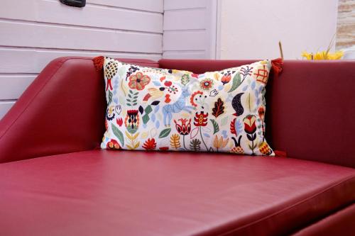 a red couch with a colorful pillow on it at Mi Casa Affittacamere in Osio Sotto