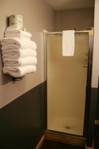 a bathroom with a shower and a stack of towels at Salt Hotel & Pub in Ilwaco