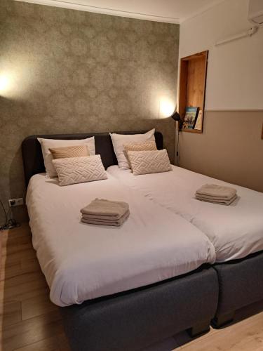 two beds in a hotel room with towels on them at Bed & Breakfast Hellendoorn in Hellendoorn