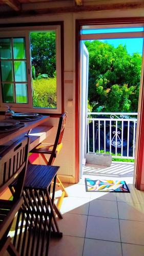 an open door to a porch with a table and chairs at Tidododesiles in Bouillante