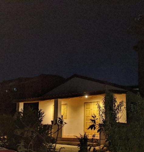 a house with a yellow door at night at Charmante petite maison toute équipée in Talata-maty