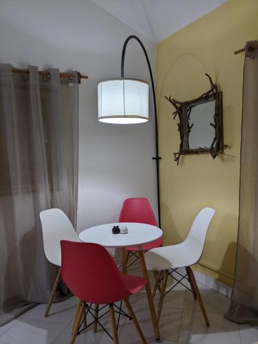 a table and four chairs in a room at Charmante petite maison toute équipée in Talata-maty