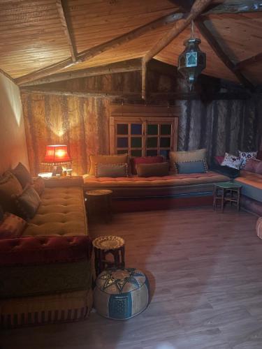 a living room with a couch and a table at Magnifique Chalet en bois collé à la forêt de Benslimane in O Ben Slimane