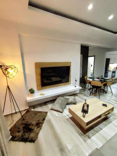 a living room with a large tv on the wall at Aneira Suite in Chalkida in Chalkida