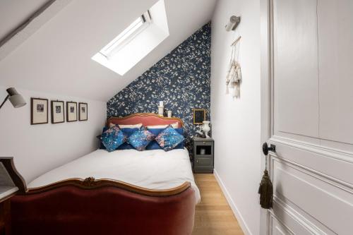 a bedroom with a bed and a blue wall at LE COTTAGE Gîte de charme au pied du Château in Combourg
