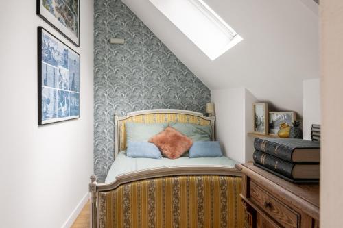 a small bedroom with a bed in a stair room at LE COTTAGE Gîte de charme au pied du Château in Combourg