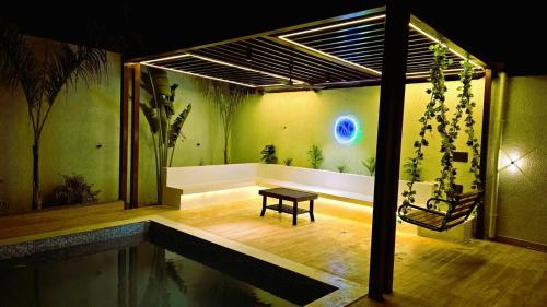 a room with a bench and a table in a room at Outhouse By Maddy in Bhopal