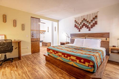 a bedroom with a bed and a desk in a room at The Classic Desert Aire Hotel in Alamogordo