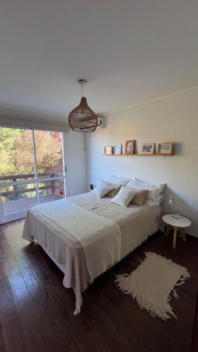 a large bed in a bedroom with a large window at Verde Lillo in Necochea