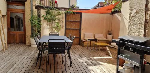 un patio avec une table, des chaises et un barbecue dans l'établissement La Maison du Coin - Parking Gratuit - Centre Ville - Commerces à Proximité, à Obernai