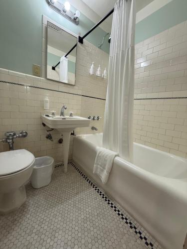 a bathroom with a tub and a toilet and a sink at The Gadsden Hotel in Douglas