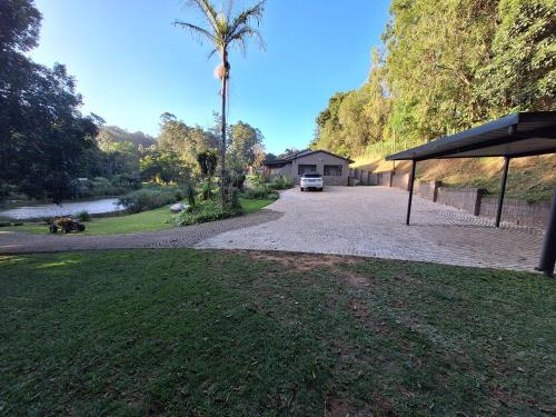 a driveway with a house and a palm tree at Studio 2 Churchill lane in Hillcrest