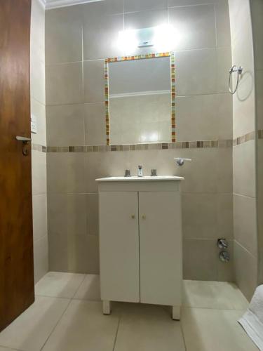 a bathroom with a white sink and a mirror at Hotel Olavarria in Olavarría