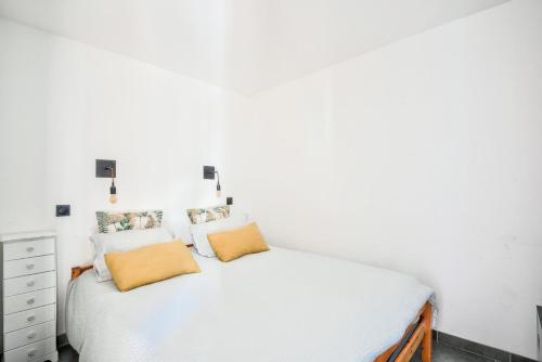 une chambre avec un lit blanc avec deux oreillers dans l'établissement Village Pont Royal en Provence - maeva Home - Appartement moderne et climatisé 2 pièces 4 personnes - Prestige - super Home MAE-0581, à Mallemort