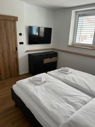 a bedroom with two beds and a flat screen tv at IQ Apartments in Prešov