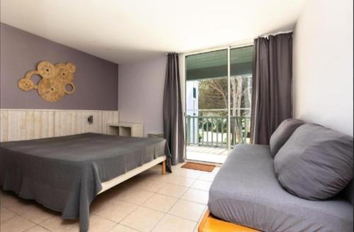 une chambre avec un lit, un canapé et une fenêtre dans l'établissement Village Moliets - maeva Home - Appartement 2 pièces 5 personnes - Prestige MAE-7051, à Moliets-et-Maa