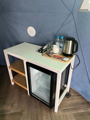 a small white table with a microwave on it at Chadir yurd glamp in İsmayıllı