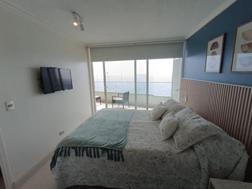 ein Schlafzimmer mit einem Bett mit Blick auf das Meer in der Unterkunft Concon Amazing Ocean View en primera linea in Concón
