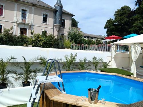 - une piscine avec une chaise à côté d'une maison dans l'établissement Le Château - maeva Home - Villa 10 pièces 18 personnes MAE-5541, à Le Soulié