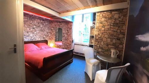 - une chambre avec un lit rouge et un mur en briques dans l'établissement Le Château - maeva Home - Villa 10 pièces 18 personnes MAE-5541, à Le Soulié