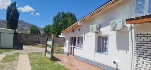 a white house with an air conditioner on the side of it at CASA PARA ALQUILER LA LILI in Uspallata