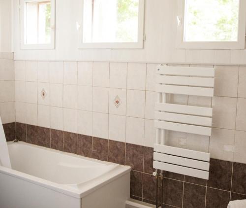 La salle de bains est pourvue d'une baignoire, de toilettes et de fenêtres. dans l'établissement Gîte Maison - Maison 4 pièces 6 personnes MAE-8901, à Le Soulié