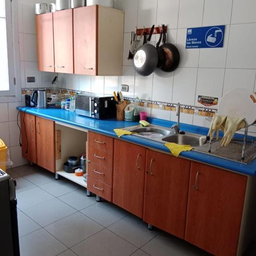 - une cuisine avec un comptoir bleu et un évier dans l'établissement hostal mancora, à Santiago