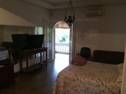 a bedroom with a bed and a television and an open door at desativado in Sao Jose do Rio Preto