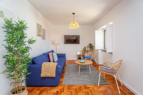 a living room with a blue couch and a table at BeGuest Cascais Blue Family Home in Cascais