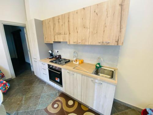 a kitchen with wooden cabinets and a stove top oven at B&B l'angoletto in Trebisacce