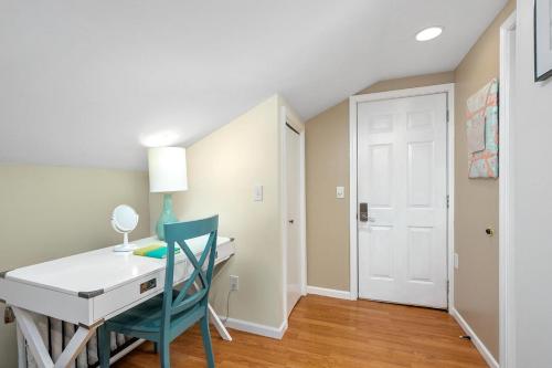a desk and a chair in a room with a door at Downtown View in Saugatuck