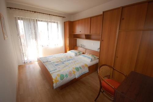 a small bedroom with a bed and a chair at Apartment Djuka in Njivice