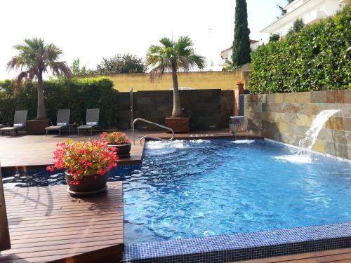 una gran piscina con una fuente en un patio en Montaltmar, en Sant Vicenç de Montalt