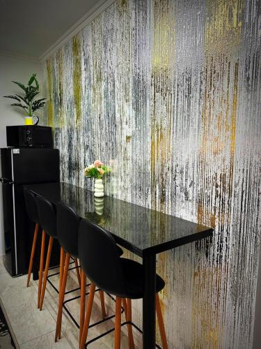 a dining table and chairs in front of a wall at Apartament 2 dormitoare LUX situat la parter in complex ApartHotel Botosani 3 in Botoşani