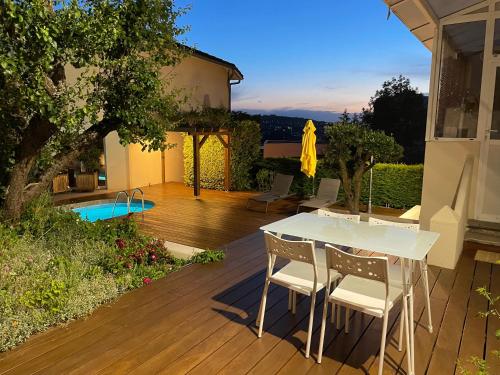 d'une terrasse avec une table blanche et des chaises. dans l'établissement À la maison, à Saint-Étienne