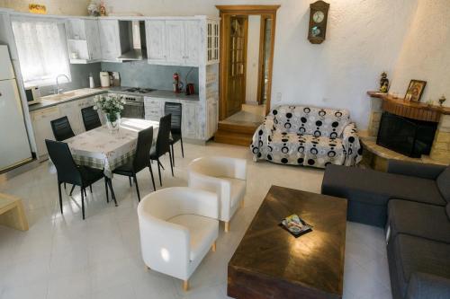 a living room with a table and chairs and a kitchen at villa eri in Kalamákion