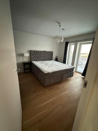 a bedroom with a bed and a wooden floor at Luxury Apartment,close to city in Örebro
