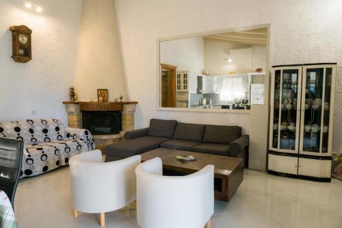 a living room with a couch and a table and chairs at villa eri in Kalamákion