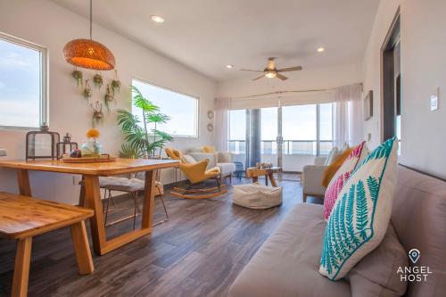 een woonkamer met een bank en een tafel bij Stylish Condo with Pools Gym Sunset Bay Views in La Paz