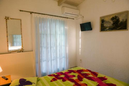 a bedroom with a bed and a window at villa eri in Kalamákion