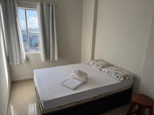 un petit lit dans une chambre avec une fenêtre dans l'établissement Apartamento perto de tudo em condomínio fechado., à Salvador