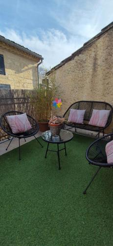 d'une terrasse avec 2 chaises et une table sur gazon. dans l'établissement Proche d'Uzès la Terrasse du soleil levant, à Collias