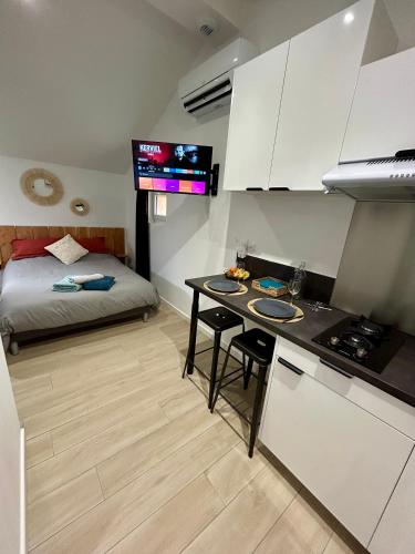 - une cuisine avec une table et un lit dans une chambre dans l'établissement Tiny house de charme toute équipée, à Le Pian-Médoc