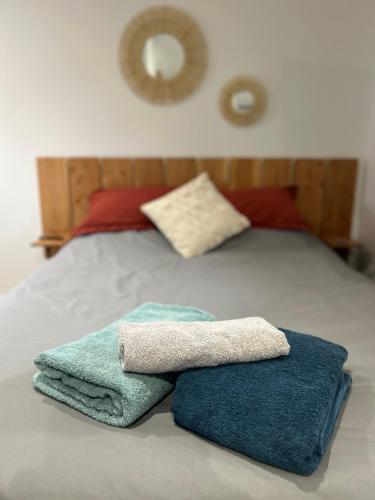 - 2 serviettes assises au-dessus d'un lit dans l'établissement Tiny house de charme toute équipée, à Le Pian-Médoc