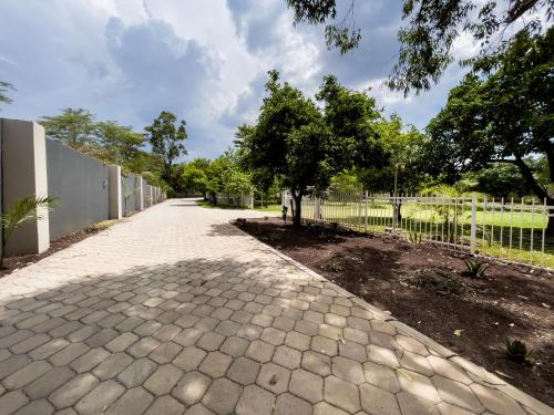 a walkway with a tree and a fence at Grananda Villas # 83E in Lusaka