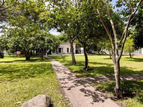 a path in a park with trees and a house at Grananda Villas # 83E in Lusaka