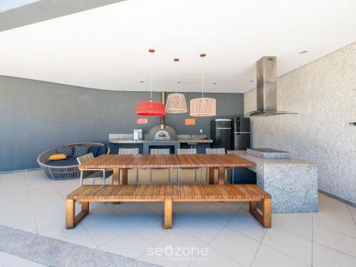 a living room with a table and a kitchen at Condomínio no litoral em Imbassaí - SOV in Imbassai